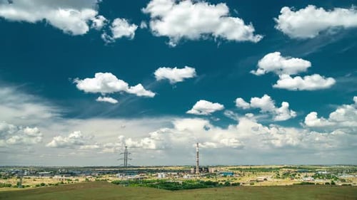 Industrial Landscape with Power Plant with Yellow Field and Big Blue Clouds. Timelapse