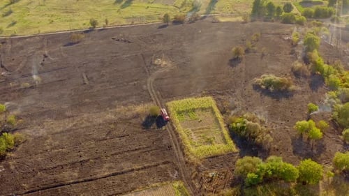 Dry grass field on fire. Aerial view of fireman truck working on the field on fire