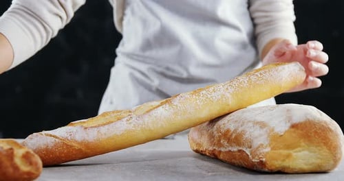 Woman arranging loaf of bread on wooden table 4k