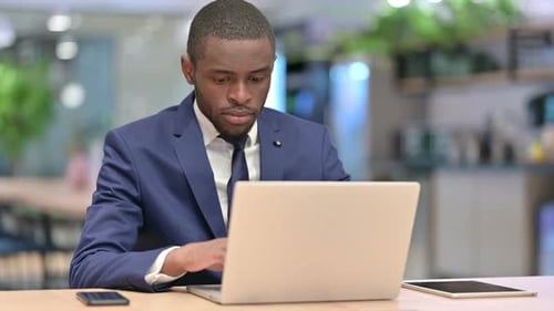 African Businessman Working on Laptop in Office
