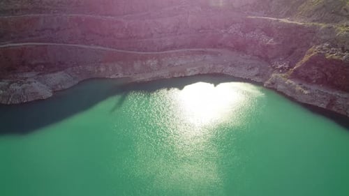 Aerial Top View on Opencast Mining Quarry with Flooded Bottom Turquoise Surface of the Lake