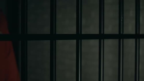 Inhaftierter Mann mit Wunden an Armen in der Nähe von Gittern, Inhaftierung nach Kampf