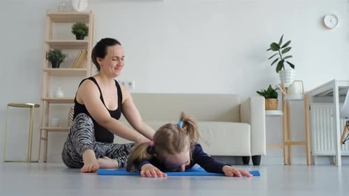 Mother and Daughter Stretching Together at Home