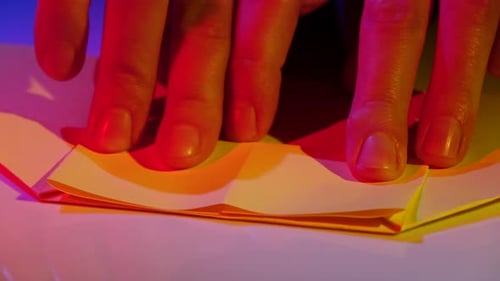 Hands Fold Paper in Artistic Close-Up
