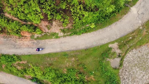 Aerial Top Down View of Motorbike Traveler Traveling on the Curvy Road in the Mountain