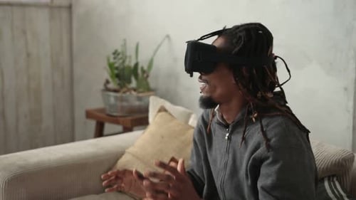 Adult Uses VR Goggles While Sitting on Sofa