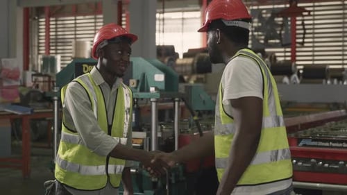 Two America worker black man wearing safety uniform with hardhat hand shake in metal sheet factory