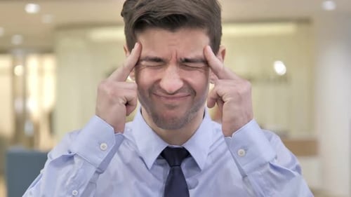 Young Adult Experiencing Headache in Office Close Up