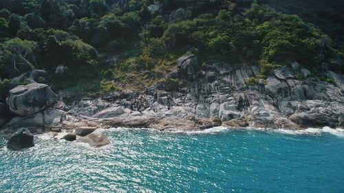 Blue Ocean Water Near Rocky Seaside Beach on Green Topical Exotic Island on Summer Vacation