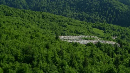 Blick von der Drohne auf einen Müllhaufen im grünen Wald