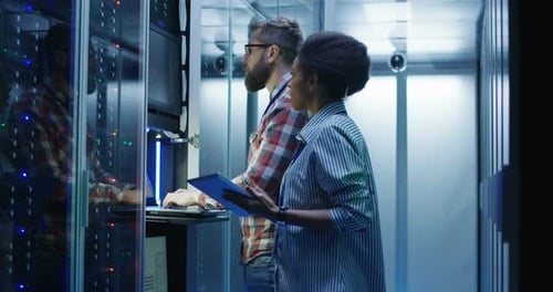Technicians Working with Laptop in Data Center