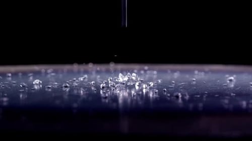 Water Droplets Falling on Dark Surface
