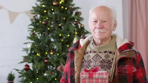 Smiling Senior Man Holding Christmas Presents