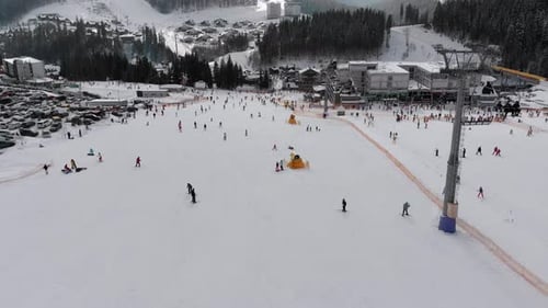 Luftaufnahme vieler Menschen, die auf Skipisten in der Nähe von Skiliften im Skigebiet Ski Ski