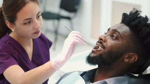 Dentist Examining a Patient's Teeth in the Dentist Office
