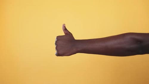 Single Arm Showing Thumbs Up on Yellow