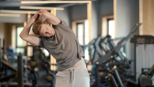 Handsome Sportsman Warming at Gym. Fitness Man Doing Exercises in Sport Club
