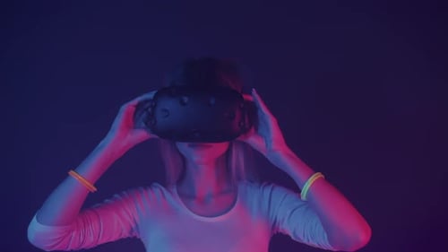 Woman Wearing Virtual Reality Headset in Neon Lighting