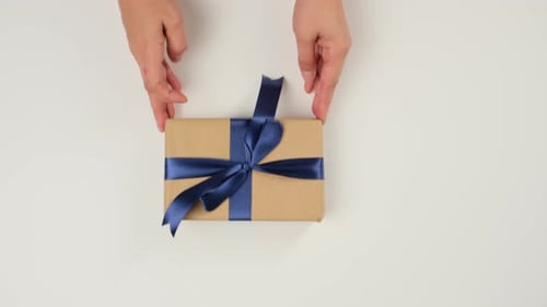 Wrapped Present with Blue Ribbon on White Table
