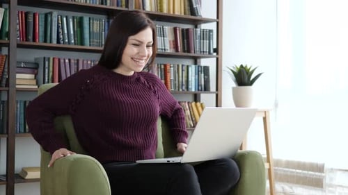Woman Using Laptop in Comfortable Armchair at Home