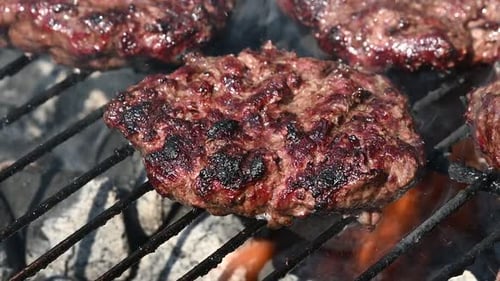 Frische Rinderfleisch-Burger für Hamburger auf dem Flammengrill kochen