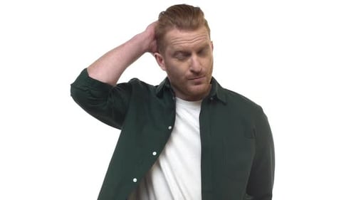 Man Looks at Camera and Scratches Head