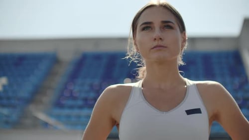 Woman Athlete Standing on Track at Stadium