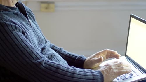 Man relaxing on sofa using laptop