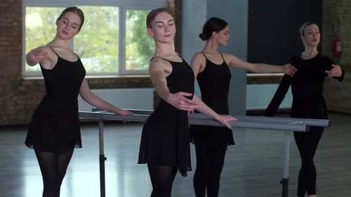 Young Women Practicing Ballet at Barre in Studio