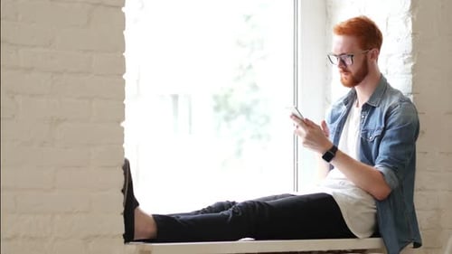 Using Smartphone, Sitting in Window, Man w/ Red Hairs and Beard