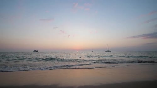 Sun setting in the horizon at beach in Koh Lanta, Thailand - wide static ultra slow motion shot