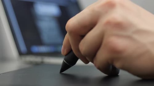 Hand Using Stylus on a Graphics Tablet