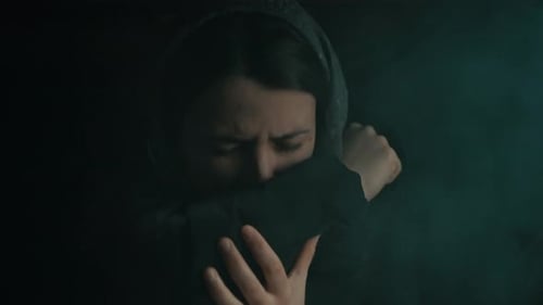 Femme suffoquant de la fumée dans le sous-sol