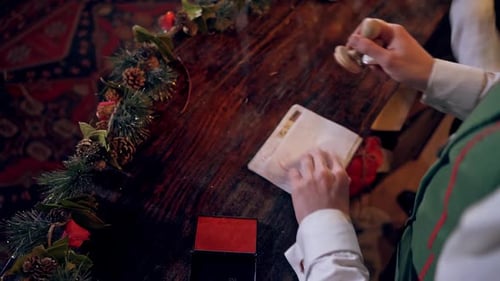 Adult Stamping Christmas Cards at Wooden Table