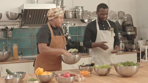 Two Adults Preparing Food in Sunny Kitchen
