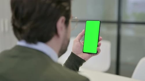 Young Adult Using Phone with Green Screen at Office
