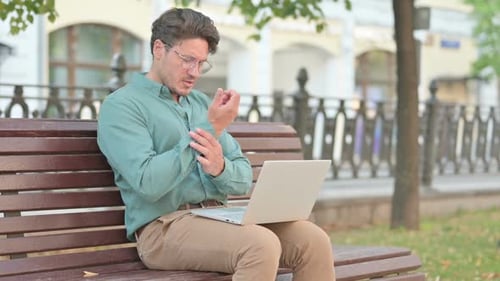 Man Typing on Laptop Rubbing Wrist in Pain
