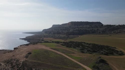 Aerial photography of the sea and mountains. The daytime sun illuminates the field.
