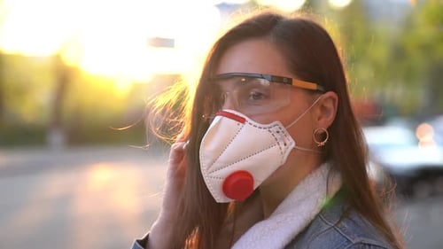 Woman Wearing Face Mask and Protective Glasses at Sunset