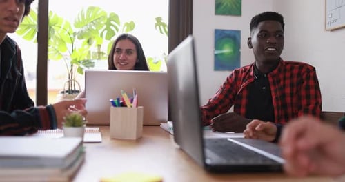 Multiracial students reading books and using laptop while studying together - School concept