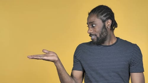 Young Adult Smiling and Gesturing with His Hand
