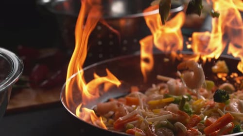 Shrimp and Vegetables Tossed with Flames in a Pan