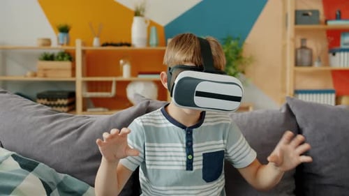 Boy Wearing VR Headset Interacting with Virtual World
