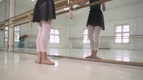 Ballet Dancer Practicing at the Barre in Studio
