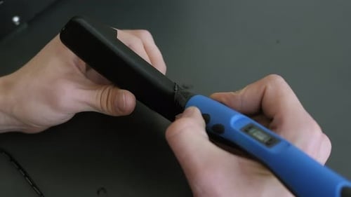 Closeup of a Male Engineer Soldering a Plastic Object with a 3D Pen