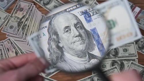 Inspecting US Currency with Magnifying Glass