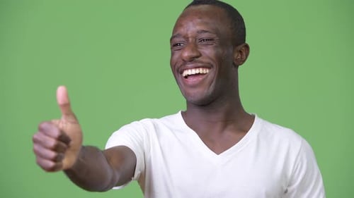 Smiling Young Adult Giving Thumbs Up Gesture