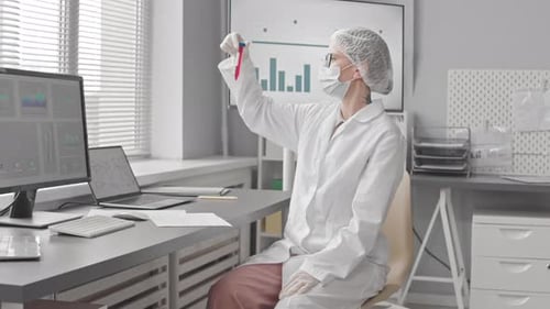 Medical Professional Examining Blood Sample in Bright Lab