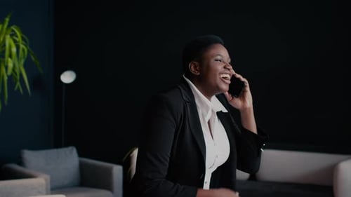 Happy Black Businesswoman In Formal Wear Talking On Cellphone At Office Hall