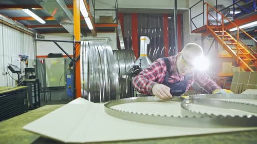 Worker Inspecting Bandsaw Teeth Sharpness